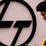 file photo an employee checks his phone next to a logo of lampt outside the larsen amp toubro precision manufacturing and systems complex on the outskirts of coimbatore